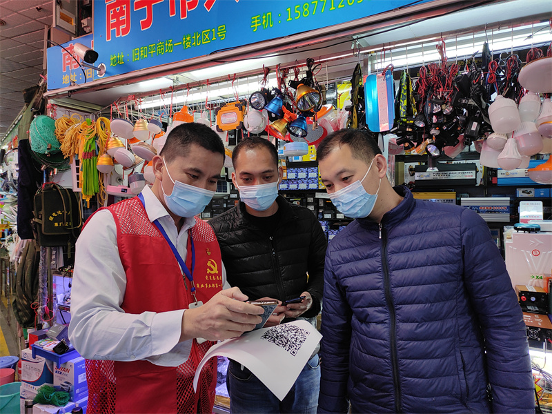 黨員志愿者指導市民下載反詐APP（拍攝：何軍）.jpg